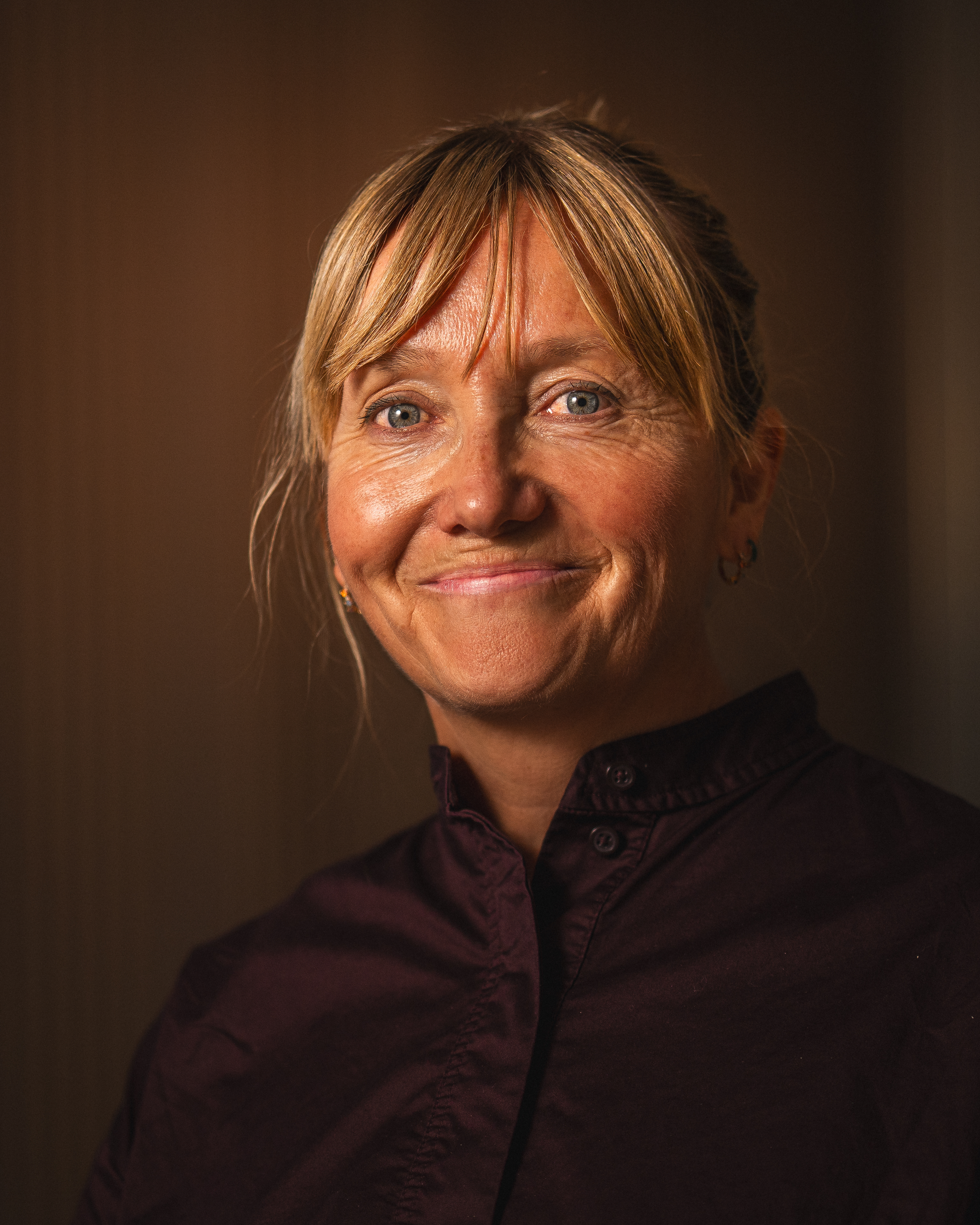 Porträtt av Helle Aanesen, daglig leder i Aktiv mot kreft, med ett vänligt leende.